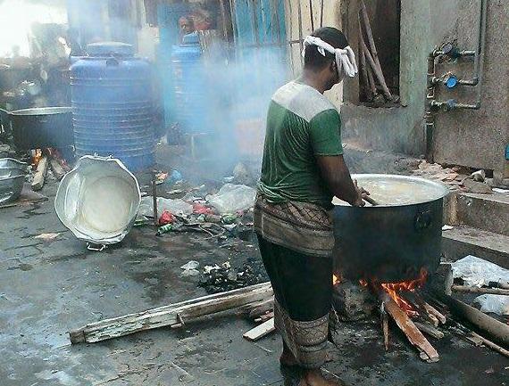 بالصور: سكان عدن يطهون طعامهم بشكل جماعي باستخدام الخشب