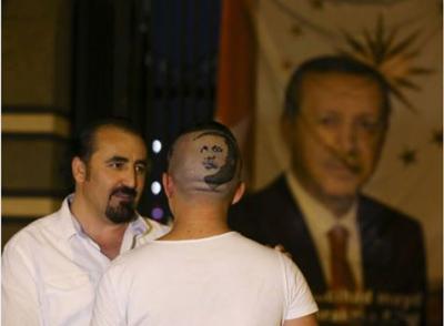 "شاهد صورة"بالمقص والشفرة.. حلاق تركي يرسم وجه أردوغان على رأس مساعده 